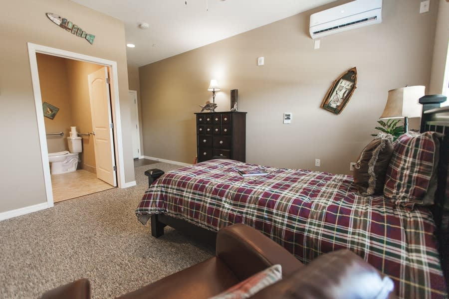 Cozy bedroom with a plaid bedspread and traditional furniture.