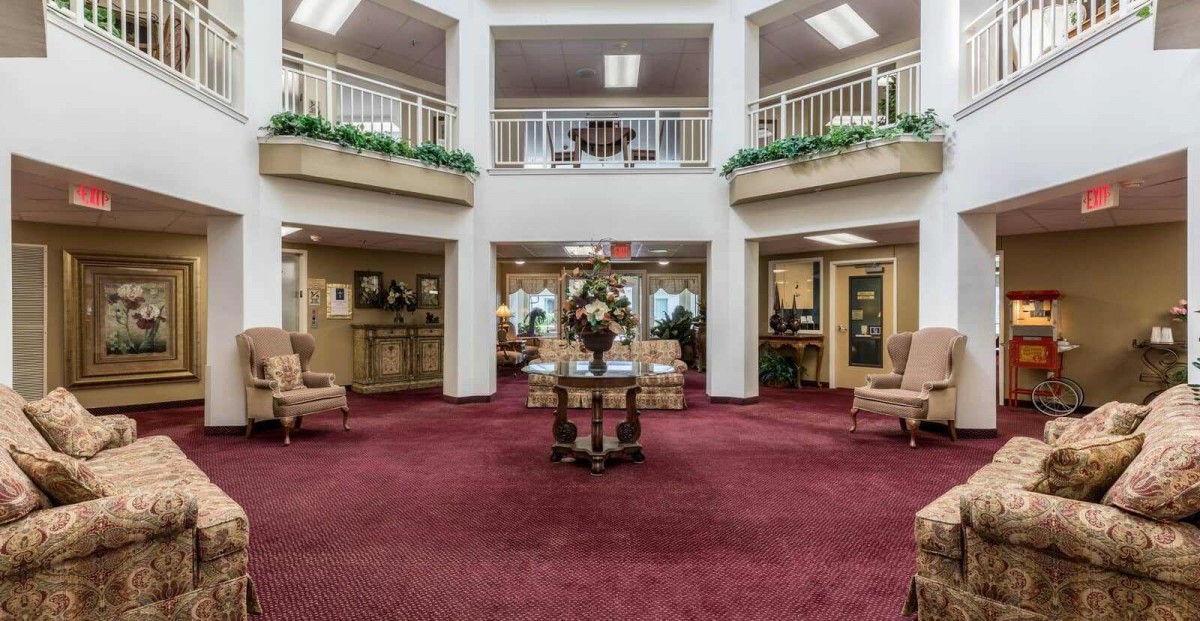 A spacious lobby area with red carpet, comfortable seating, and elegant decor.