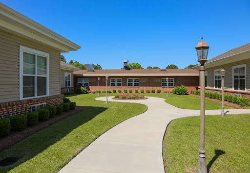 A well-maintained pathway leading through a landscaped area towards the building.