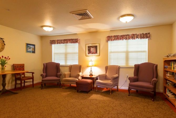 A cozy living room with several chairs arranged around a central lamp.