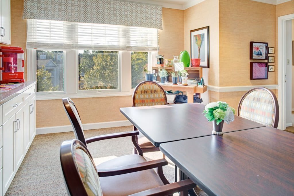 A well-lit dining area with a table, chairs, and decor near a window.