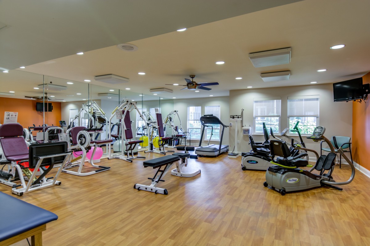 A well-equipped gym with various exercise machines and open space.