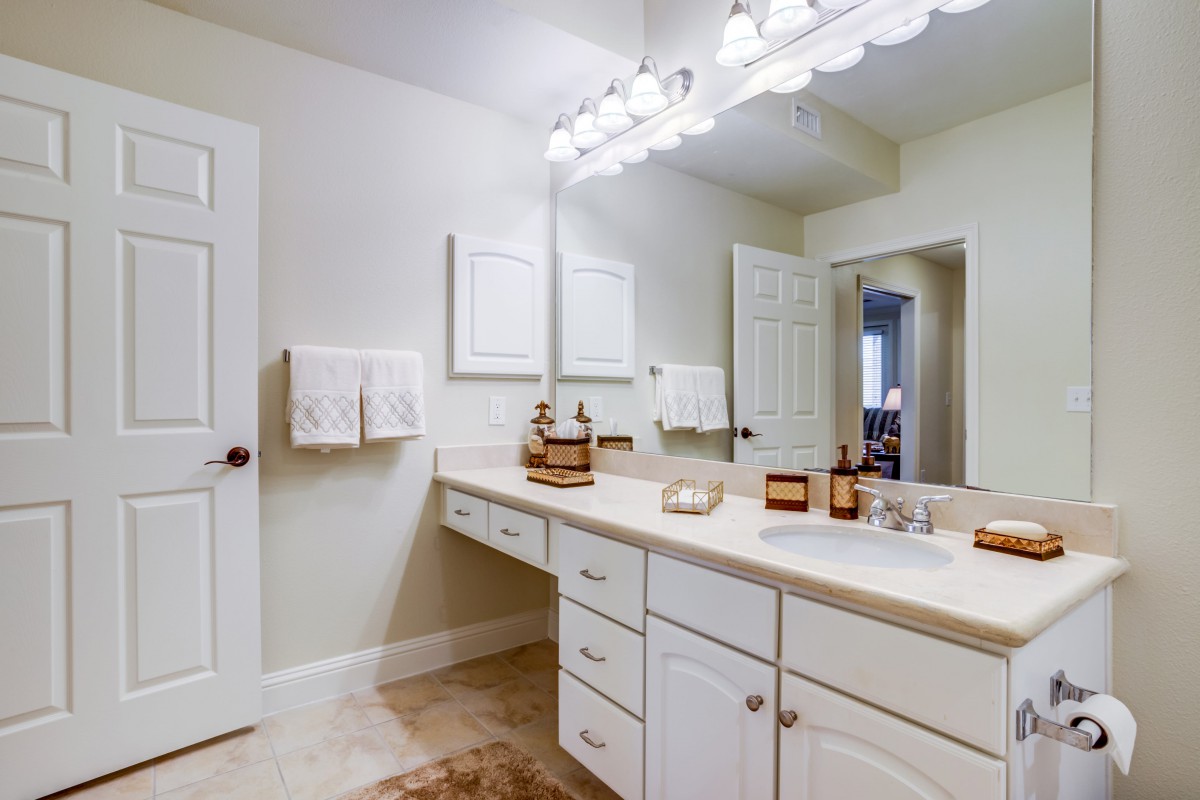 A well-lit bathroom with a spacious countertop and mirror.