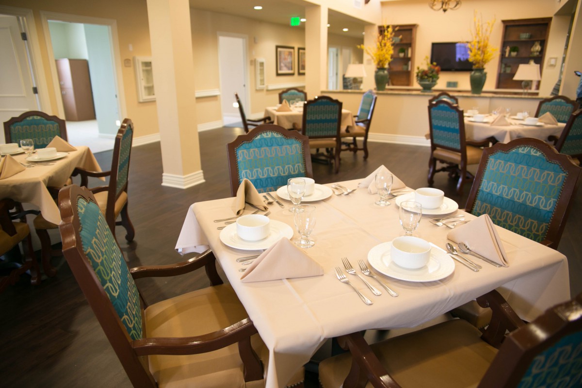 An elegantly set dining table in a restaurant with stylish chairs and neatly arranged tableware.