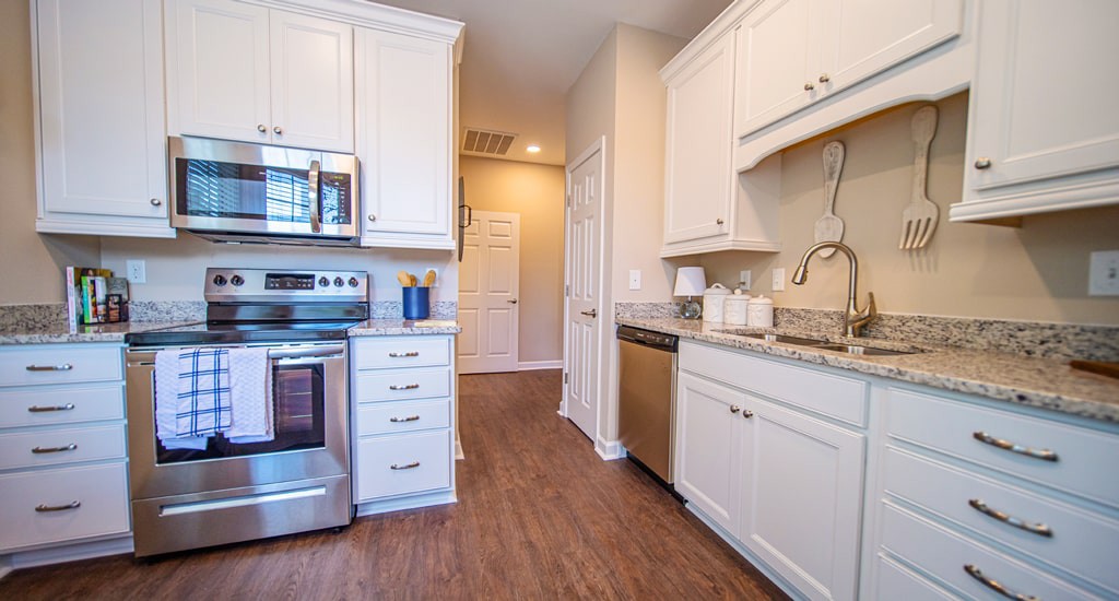 A modern kitchen with stainless steel appliances and white cabinets.