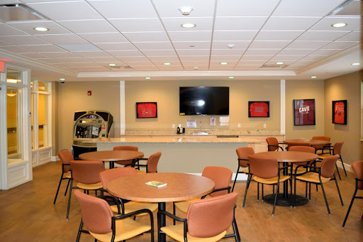 A well-furnished common area featuring tables, chairs, and a television.