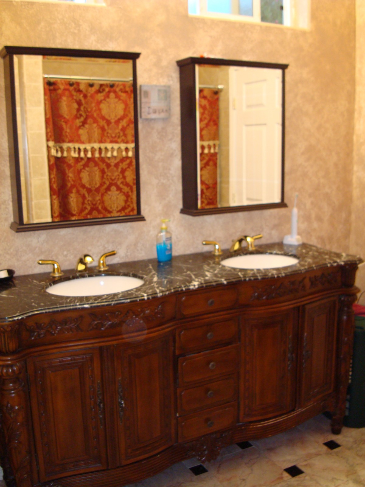 A double sink bathroom vanity with dark wood cabinetry and two mirrors.