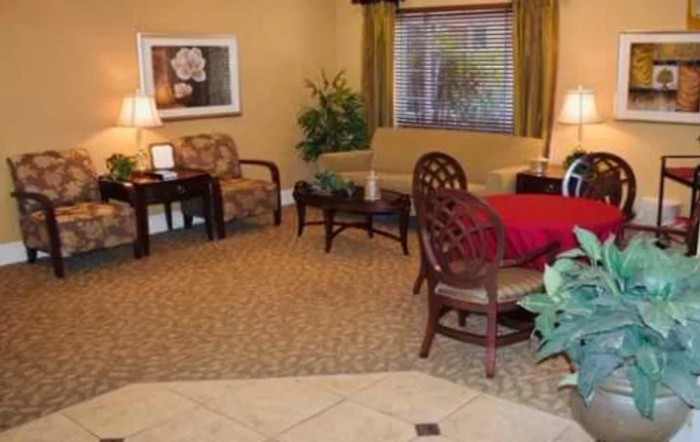 A cozy living room with a sofa, armchair, table, and decorative elements.