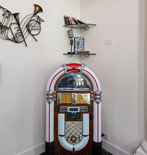 A vibrant jukebox complemented by musical decor on the wall.