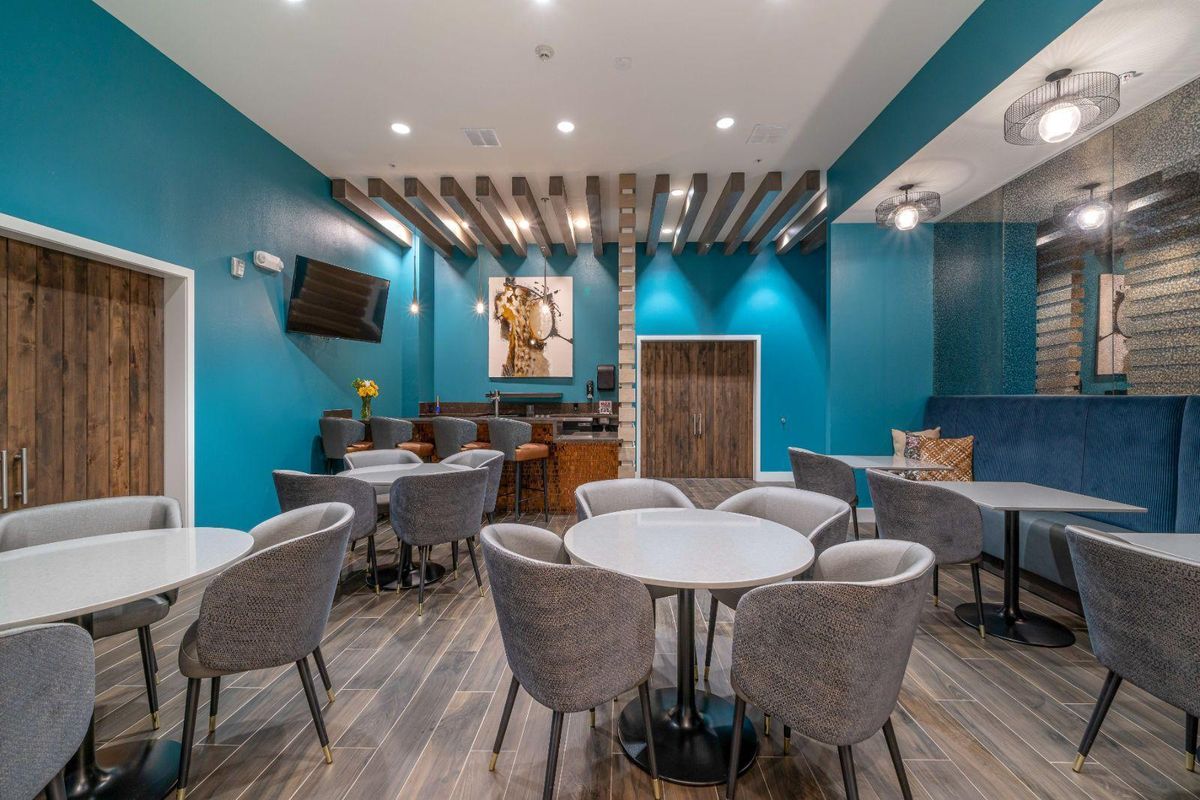 Modern restaurant dining area with blue walls and stylish furniture.