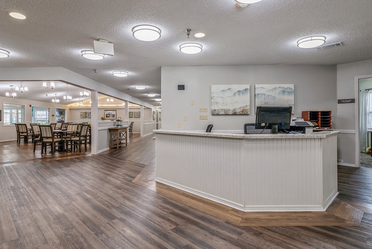 A modern reception area with a front desk and artwork on the walls.