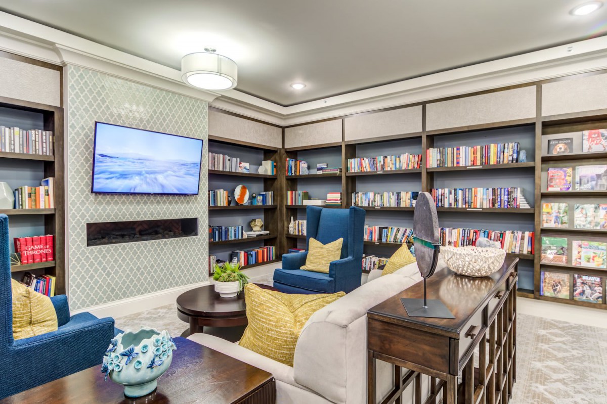 A modern living room featuring built-in bookshelves, a cozy seating area with a comfortable armchair, and stylish decor.
