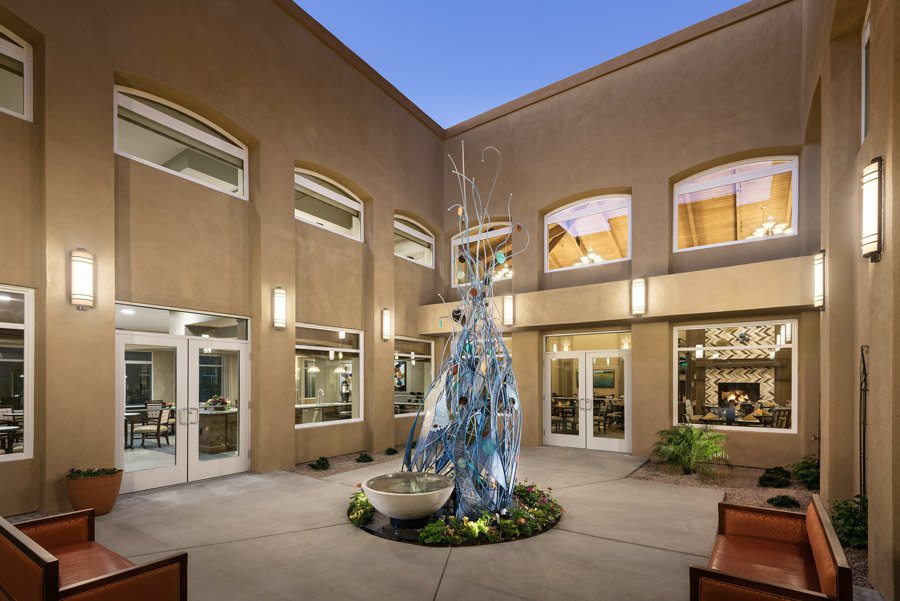 A well-lit courtyard with a central fountain surrounded by a modern building.