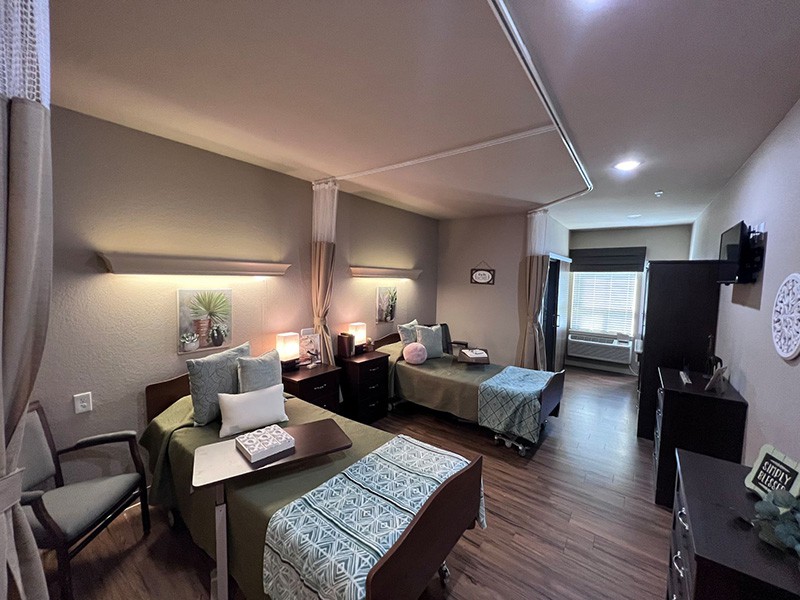 A modern healthcare room with two neatly arranged beds and soft lighting.