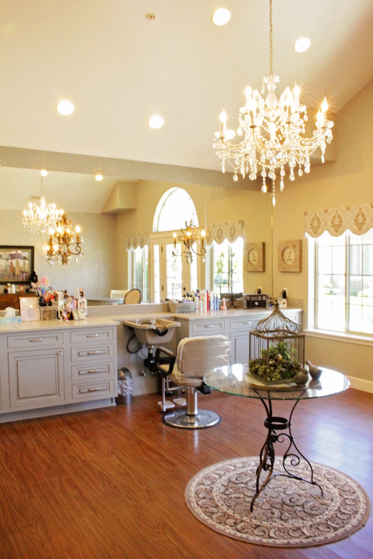 A luxurious salon interior featuring chandeliers, large mirrors, and elegant decor.