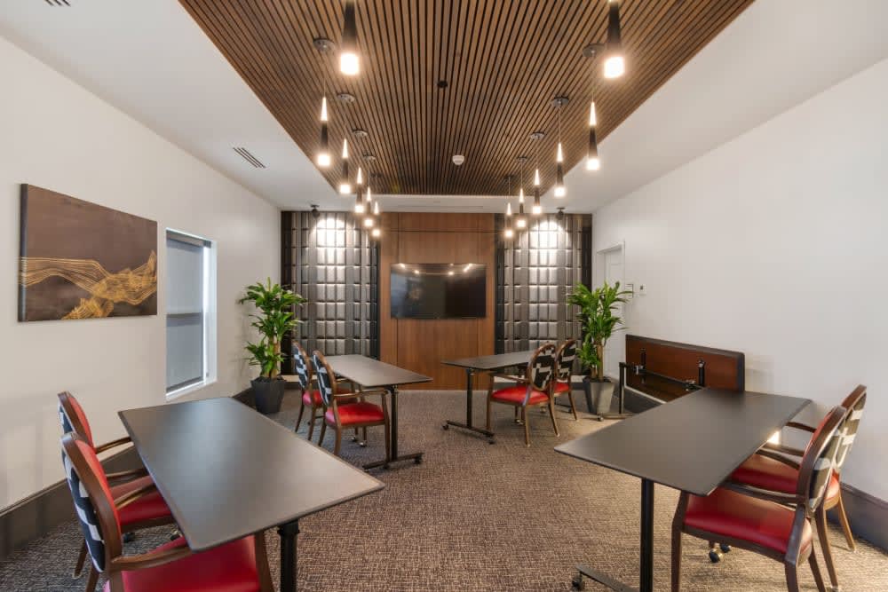 A modern meeting room with sleek tables and chairs, stylish lighting, and decorative plants.