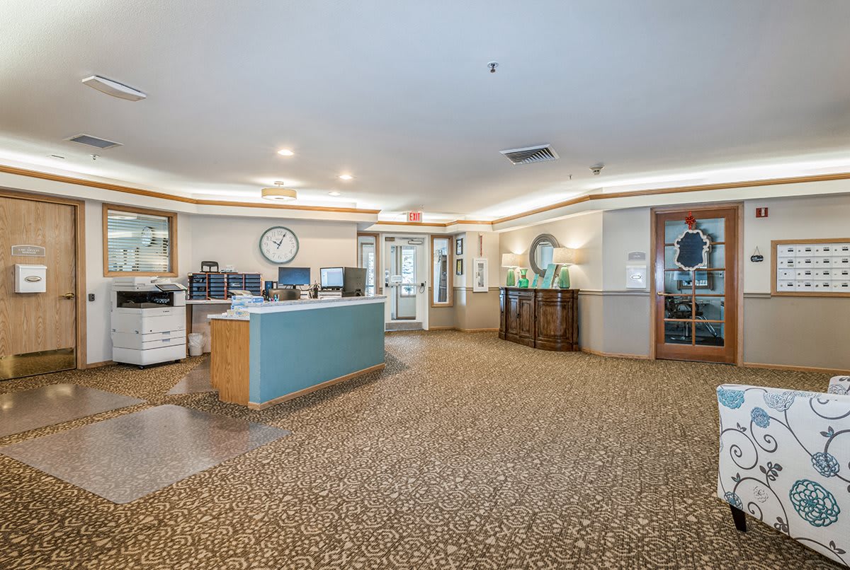 A spacious and well-lit reception area with a central desk and modern decor.