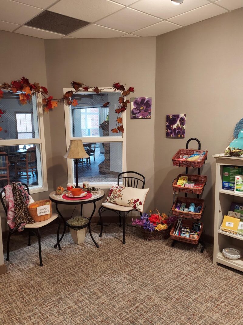 A cozy, autumn-themed interior with small tables and decorative shelves.