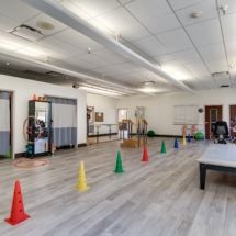An indoor gym space with exercise cones set up for training.