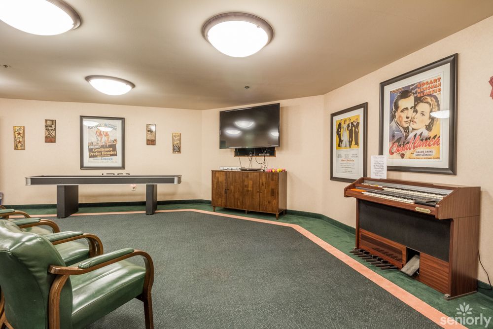 A vintage-style room with a television, artwork on the walls, and classic furniture.