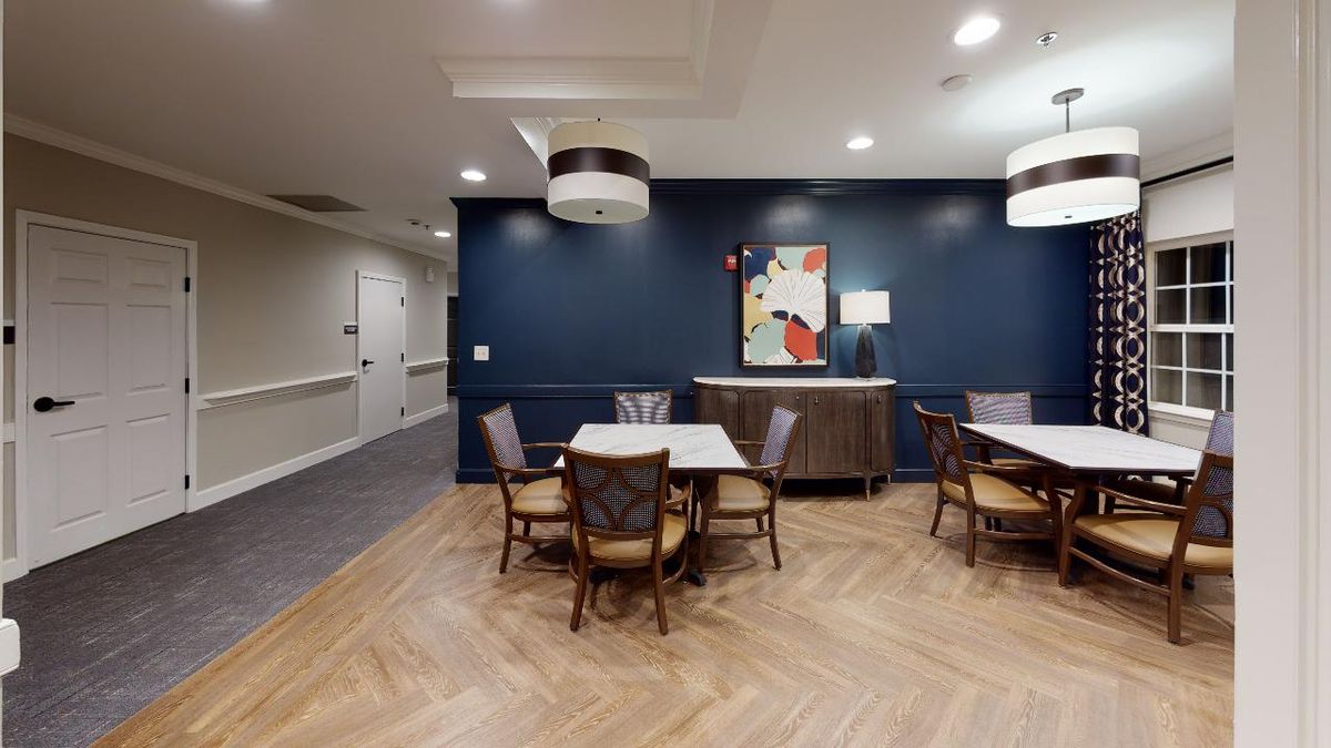 A cozy dining area with tables, chairs, and decorative lighting.
