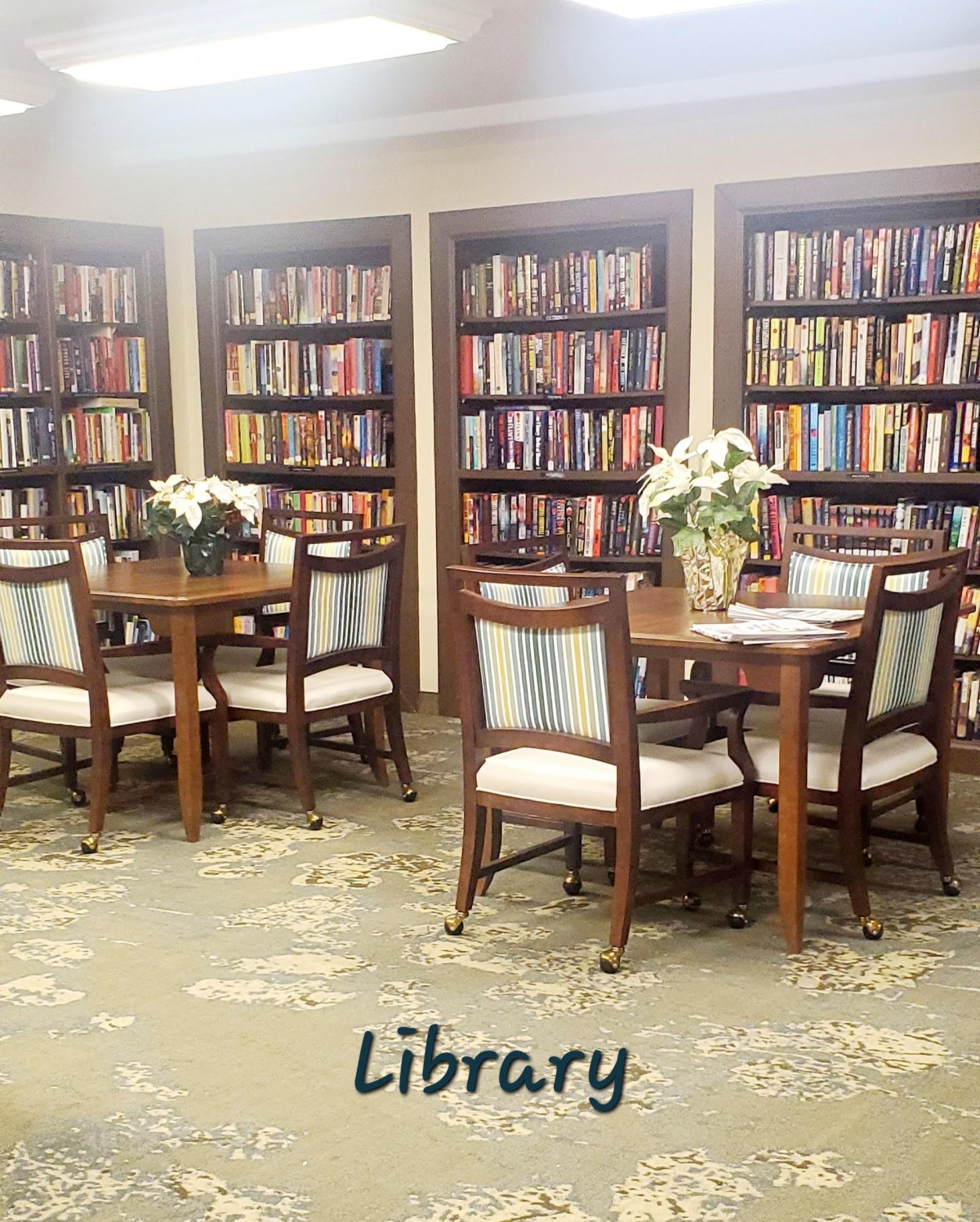 A cozy library corner with bookshelves, tables, and chairs for reading.