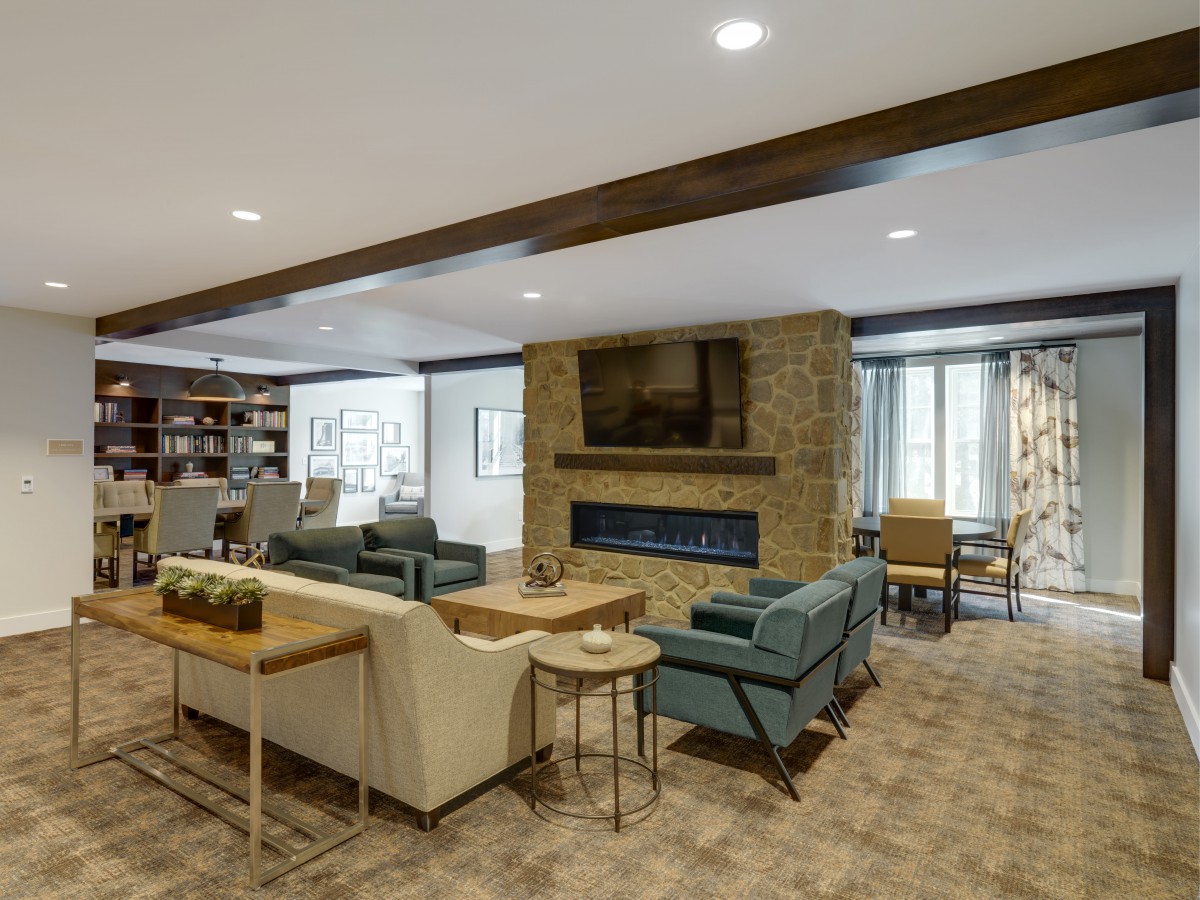 A modern living room with comfortable seating and a stone fireplace.