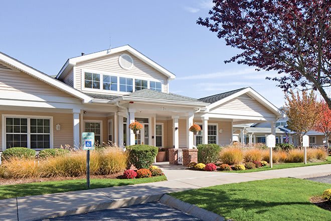 A well-maintained building with a landscaped garden and lawn area.