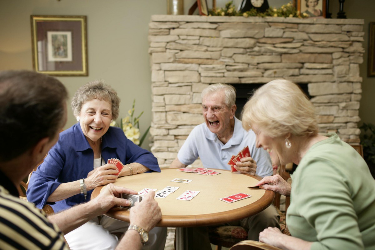 A group of seniors enjoying a card game together indoors.