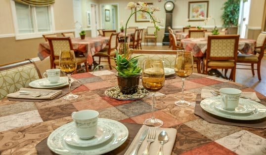An elegantly set dining table with a decorative centerpiece in a cozy dining room.