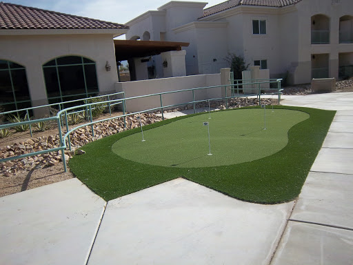 A well-designed miniature golf area with artificial grass in a residential setting.