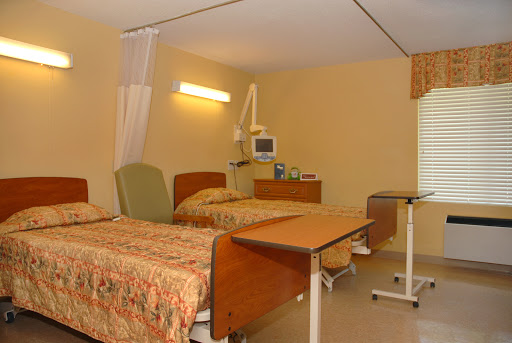 A clean and well-organized hospital room equipped with two patient beds and essential medical facilities.