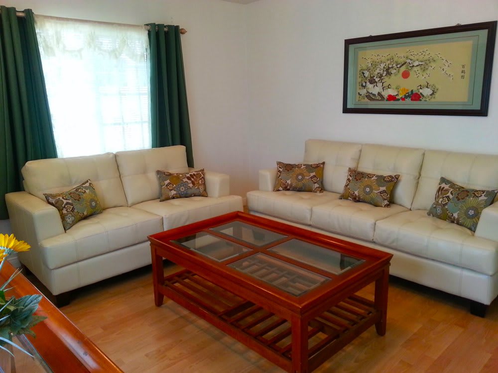 A cozy living room with two cream-colored sofas and a wooden coffee table.