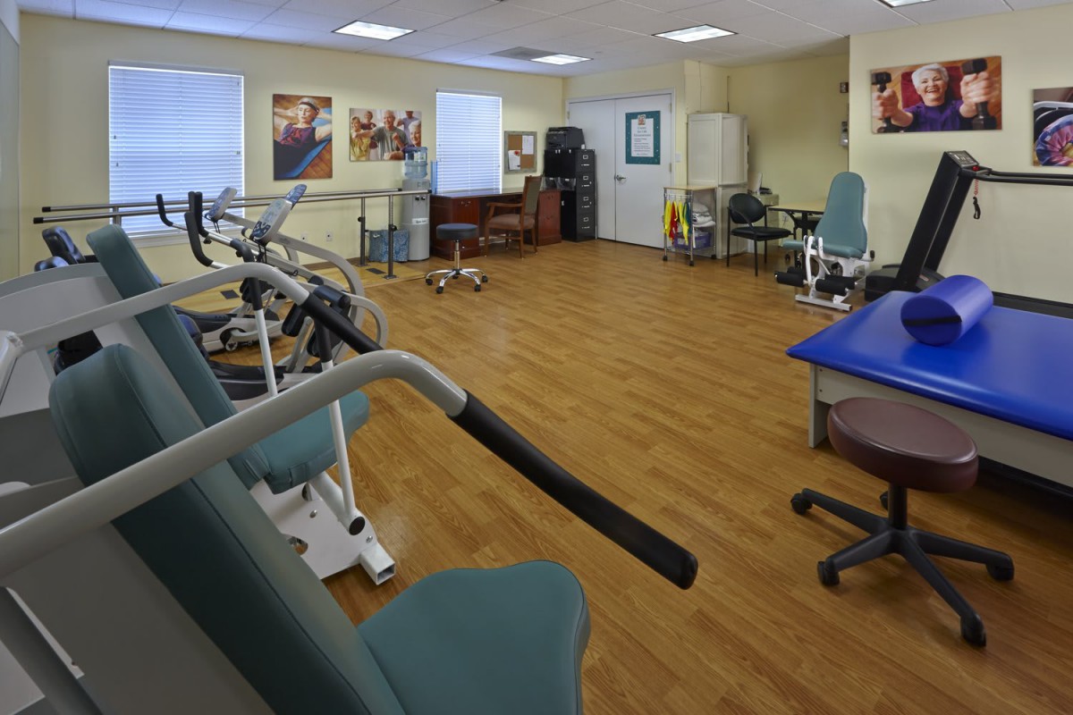 A well-equipped physical therapy room with various exercise machines and rehabilitation tools.