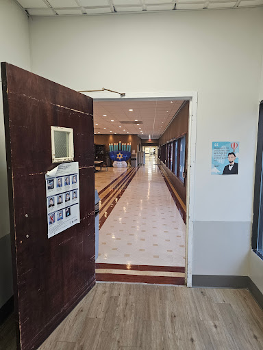 A view through an open door leading into a well-lit corridor.