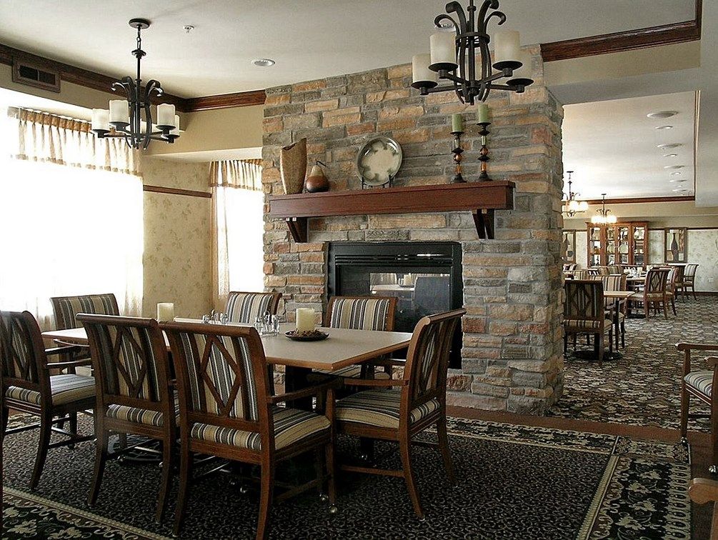 A cozy dining room featuring a stone fireplace and wooden furniture.