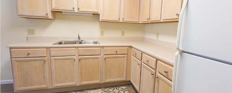 A kitchen with light wood cabinets and a clean countertop.