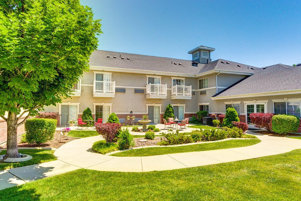 A well-maintained residential building with beautiful landscaping and a sunny courtyard.