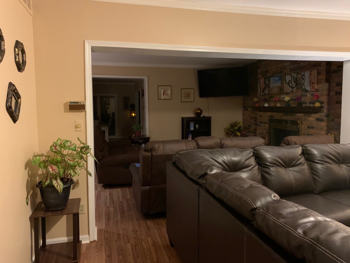 A cozy living room with a large sectional sofa, fireplace, and television.