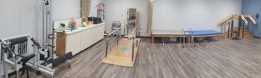 A physical therapy room equipped with parallel bars for rehabilitation exercises.