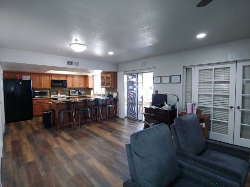 A spacious open-concept kitchen and living room area showcasing modern design elements and wooden flooring.