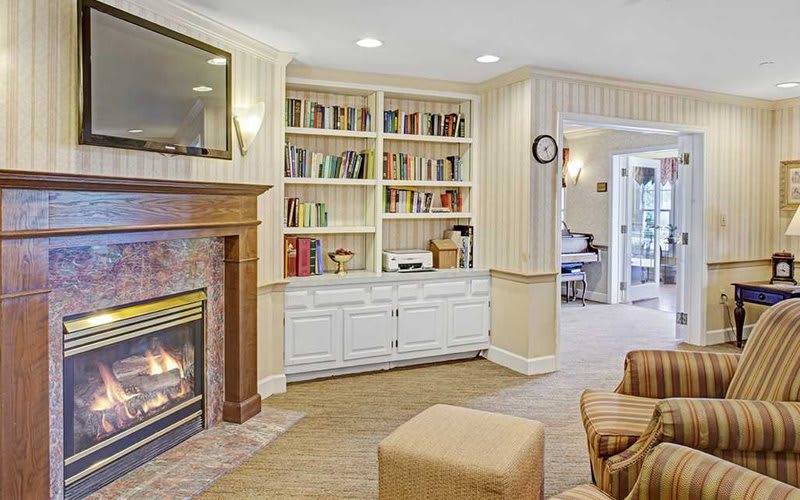 A cozy living room with a fireplace and built-in bookshelf.