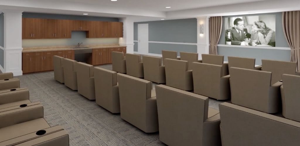 A modern conference room with comfortable seating and a projector screen.
