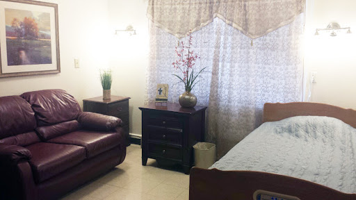 A cozy bedroom setup featuring a sofa, bedside table, and natural lighting.
