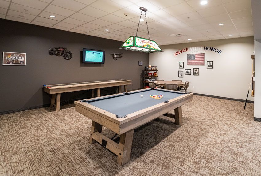 A cozy game room featuring a billiards table and shuffleboard.