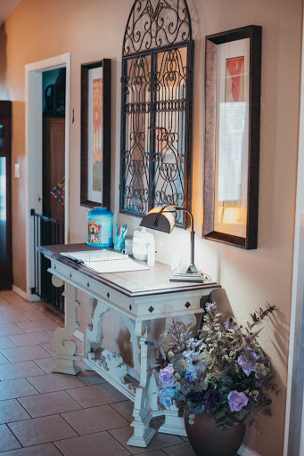 A beautifully decorated entryway featuring a stylish table, framed artwork, and soft natural lighting.