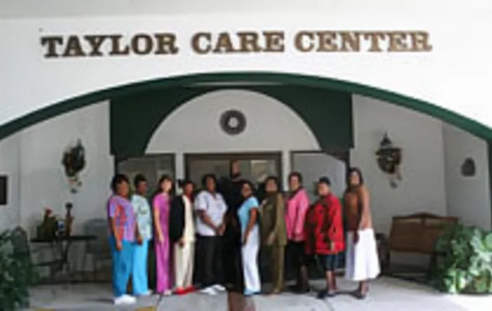 A group of people standing in front of a care center entrance.