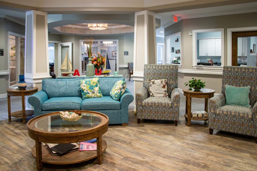 A cozy living room interior with a sofa, armchair, and coffee table.