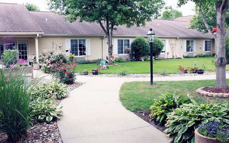 A neatly landscaped garden with a winding pathway leading to a house.