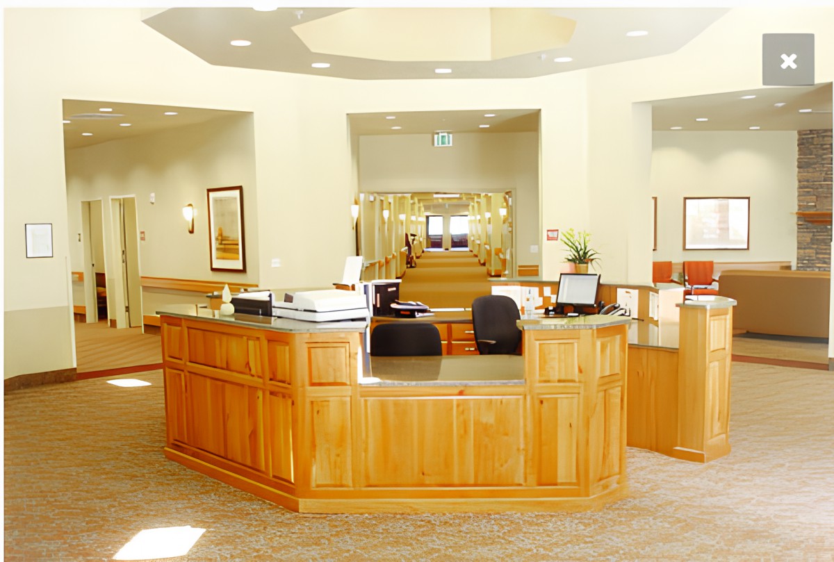 A bright and welcoming reception area with a central desk and office furnishings.